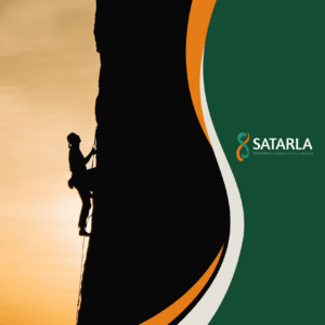 A rock climber scales a cliff at sunset.